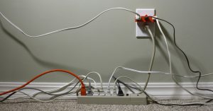 Still Life of an Electrical Wall Outlet Overloaded with Wires and Cables